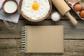 Blank recipe book and different ingredients on wooden table, flat lay. Space for text Royalty Free Stock Photo