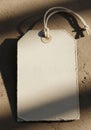 A blank, rectangular tag made of textured white paper lies on a rough surface. The tag Royalty Free Stock Photo