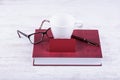 Blank red business card and white mug mock-up. Red book, pen and glasses on white wooden background Royalty Free Stock Photo