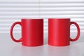 Blank red ceramic mugs on white table. Mockup for design Royalty Free Stock Photo