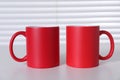 Blank red ceramic mugs on white table. Mockup for design Royalty Free Stock Photo