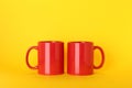 Blank red ceramic mugs on yellow background Royalty Free Stock Photo