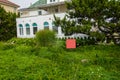 A blank red sign in a overgrown yard in front of a large stucco house Royalty Free Stock Photo