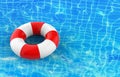 a blank rescue life ring floating on Waving blue swimming pool rippled water surface background.