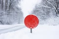 A blank road traffic sign warning of winter driving conditions on a road