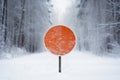 A blank road traffic sign warning of winter driving conditions on a road