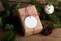 Blank round Christmas gift tag mockup with present box, product label mockup, with natural fir tree branch Royalty Free Stock Photo