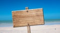 Blank rustic wooden sign on the beach