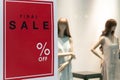Blank Sale Sign With Various Percentage Signs on Red Background in front a Female mannequins in the fashion store.
