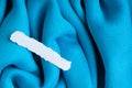 Blank scrap of paper on blue cloth wavy folds textile background Royalty Free Stock Photo