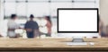 Blank screen desktop computer on wooden table top with blur people working at creative office bokeh background,Mock up for