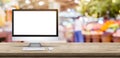 Blank screen desktop computer on wooden table top with blur people shopping at supermarket bokeh background,Mock up for display or Royalty Free Stock Photo