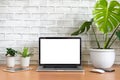 Blank screen of Laptop computer with tablet, mobile phone, mouse and monstera plant pots