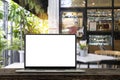 Blank screen laptop computer on wood table top with blur cafe restaurant with abstract bokeh light defocused Royalty Free Stock Photo