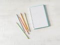 Blank sheet notebook with copy space for text and multicolored graphite pencils on white background. Flat lay, top view girl work Royalty Free Stock Photo