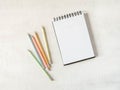 Blank sheet notebook with copy space for text and multicolored graphite pencils on white background. Flat lay, top view girl work Royalty Free Stock Photo