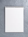 Blank sheet of notebook with a spiral on a neutral gray textured Royalty Free Stock Photo