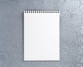 Blank sheet of notebook with a spiral on a neutral gray textured Royalty Free Stock Photo