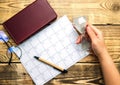 A blank sheet of notepad and a calendar for planning for a month or a year. Glasses, notepad and pen