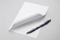 Blank sheet of paper with curled corner and pen Royalty Free Stock Photo