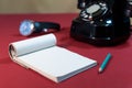 Blank sheet of paper in a notepad. Old fashioned scene. An ink pen, an old telephone and a wrist watch. selected focus Royalty Free Stock Photo