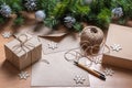 Blank sheet of paper, pen, gifts in handmade boxes, twine, artificial spruce branches and wooden snowflakes. Royalty Free Stock Photo