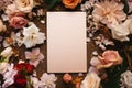 A blank sheet of paper on the sand surrounded by flowers. Top view of invitation card, advertisement and postcard mockup