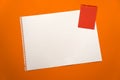 Blank sheet of paper space for design and lettering on a beautiful orange background red notepad sheet. Perforated sheet torn from