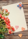 Blank sheet of paper on wooden surface with roses Royalty Free Stock Photo
