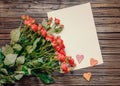 Blank sheet of paper on wooden surface with roses Royalty Free Stock Photo