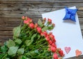 Blank sheet of paper on wooden surface with roses