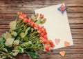 Blank sheet of paper on wooden surface with roses Royalty Free Stock Photo