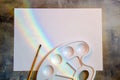 Blank sheet of white paper with rainbow, paint brush and blank white palette for mixing paints Royalty Free Stock Photo
