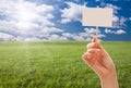 Blank Sign in Hand Over Grass Field and Sky Royalty Free Stock Photo