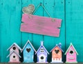 Blank sign with heart hanging by row of birdhouses
