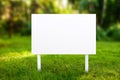 Blank Signboard on Lush Green Grass Surrounded by Nature, Ready for Customization or Message Display in a Peaceful Setting Royalty Free Stock Photo