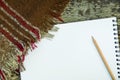 Blank sketchbook pencil checkered brown red grey plaid on weathered wood bench in park. Arts sketching drawing creativity concept