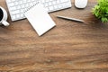 Blank small notebook with pen and computer gadgets are on top of wood office desk table. Top view, flat lay Royalty Free Stock Photo