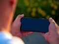 Mock up man using smartphone blank display mobile phone background. Caucasian man watching smartphone screen holding on horizontal Royalty Free Stock Photo