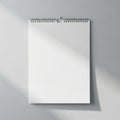 Blank spiral bound wall calendar page with soft sunlight shadows isolated on white background Royalty Free Stock Photo