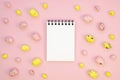 Blank spiral notebook bordered with quail Easter eggs on a pink table. Copy space for your text Royalty Free Stock Photo