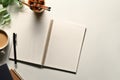 Blank spiral notebook, pencil holder and coffee cup on white table. Top view with copy space for text Royalty Free Stock Photo