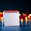 A blank spiral notebook with a red wire binding, set against a backdrop of softly blurred lights Royalty Free Stock Photo