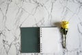 Blank spiral notebook with yellow rose flower on white and gray marble background. Minimal design with copy-space. Royalty Free Stock Photo