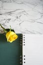 Blank spiral notebook with yellow rose flower on white and gray marble background. Minimal design with copy-space. Royalty Free Stock Photo