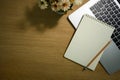 Blank spiral notepad, pencil and laptop computer in wooden working desk. Top view with copy space Royalty Free Stock Photo