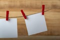 Blank square note paper card hanging with wooden clip or clothespin on rope string peg. Copy space Royalty Free Stock Photo