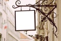 Blank square signboard, hanging from wrought iron bracket Royalty Free Stock Photo