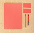 Blank Stationery on cork board. Consist of Business cards, A4 letterheads, pen and pencil.