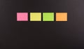 Blank sticky note in a row on black background , four paper sheet background.